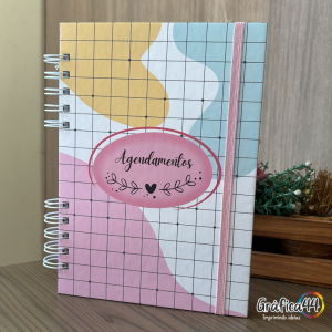 Caderno de Agendamentos Folhas Internas Papel Offset 75g. 15 x 21 cm - 250 Páginas Impressão Colorida. Capa dura com Laminação. wire-o Bolso Plástico Transparente e Fechamento com Elástico.